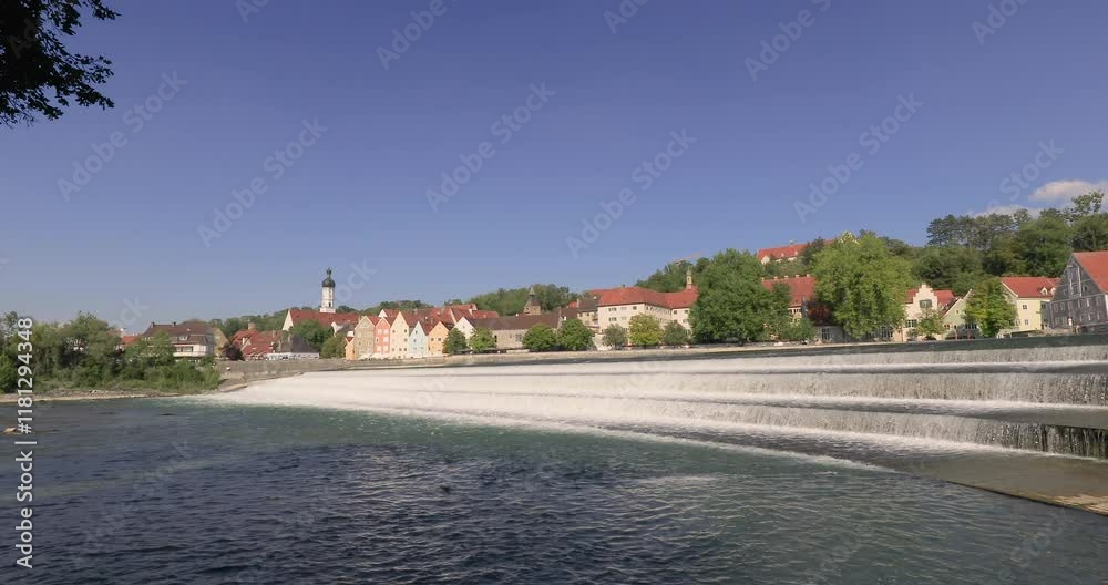 Locked off stationary motion of the cascading water over the weir on the River Lech with the old town of Landsberg am Lech in background, Landsberg, Upper Bavaria, Germany Locked off stationary motion of the cascading water over the weir on the River Lech with the old town of Landsberg am Lech in background, Landsberg, Upper Bavaria, Germany