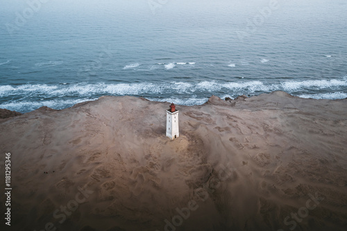 Aerial view of rubjerg lighthouse surrounded by scenic sand dunes and the tranquil north sea, Jutland, Denmark. photo