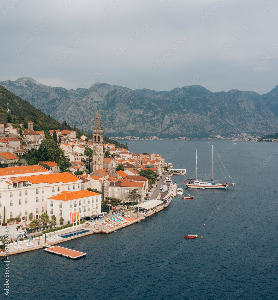 Aerial view of the picturesque Church of Saint Nicholas with sailboats on turquoise waters and mountains in the background, Perast, Montenegro. Aerial view of the picturesque Church of Saint Nicholas with sailboats on turquoise waters and mountains in the background, Perast, Montenegro.