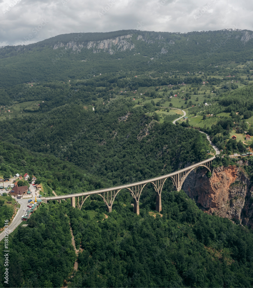 Aerial view of tara bridge spanning a lush canyon surrounded by majestic mountains and serene forest, Zabljak, Montenegro. Aerial view of tara bridge spanning a lush canyon surrounded by majestic mountains and serene forest, Zabljak, Montenegro.