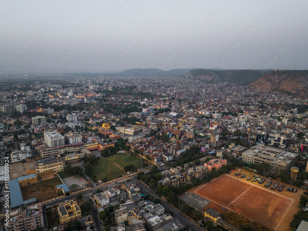 Aerial view of vibrant cityscape with dense buildings and hills under sunset, Sindhi Camp, Jaipur, Rajasthan, India. Aerial view of vibrant cityscape with dense buildings and hills under sunset, Sindhi Camp, Jaipur, Rajasthan, India.