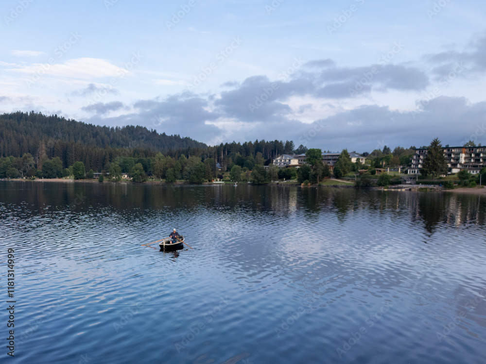 Aerial view of tranquil lake surrounded by serene forest and picturesque boats, Titisee-Neustadt, Germany. Aerial view of tranquil lake surrounded by serene forest and picturesque boats, Titisee-Neustadt, Germany.