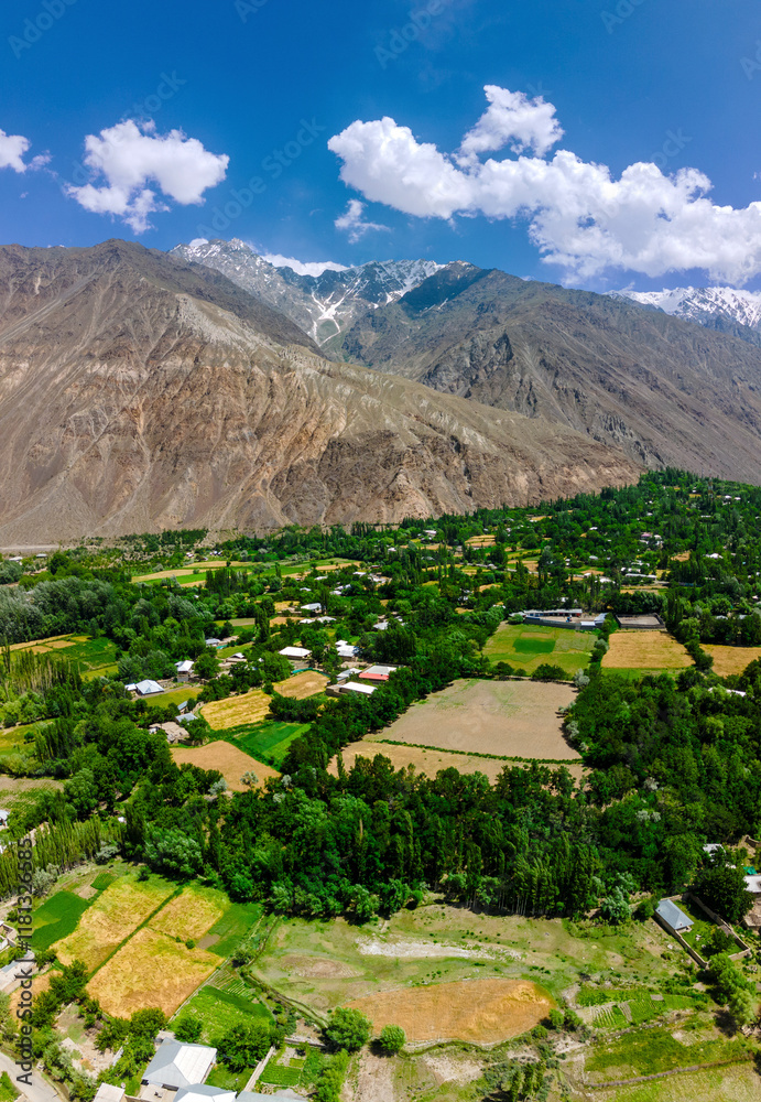 Aerial view of scenic mountains and lush valley with a village and fields, Mastuj, Pakistan. Aerial view of scenic mountains and lush valley with a village and fields, Mastuj, Pakistan.