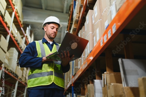 Warehouseman checking delivery, stock in warehouse on laptop. Warehouse manager using warehouse management software, app.