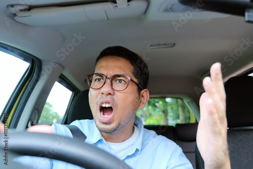 A car driver showing angry gesture when driving his car