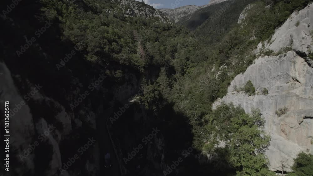 This drone video features a stunning frontal descriptive shot along the winding road of Boca del Infierno Gorge in the Western Valleys Natural Park, Huesca, Spain, surrounded by majestic mountains. This drone video features a stunning frontal descriptive shot along the winding road of Boca del Infierno Gorge in the Western Valleys Natural Park, Huesca, Spain, surrounded by majestic mountains.