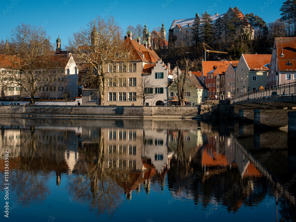 Fototapeta premium Historic Town Of Landsberg Am Lech In Bavaria: Winter Charm With A Frozen River And Colorful Houses Under A Clear Blue Sky