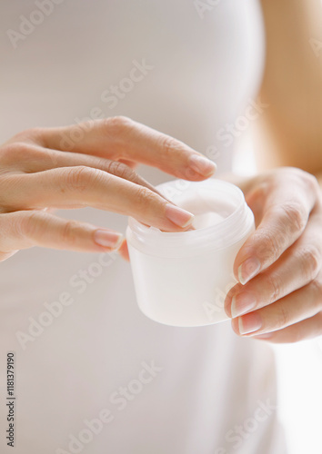 Woman Holding an Open Jar of Cosmetic Cream, Close up view
 photo