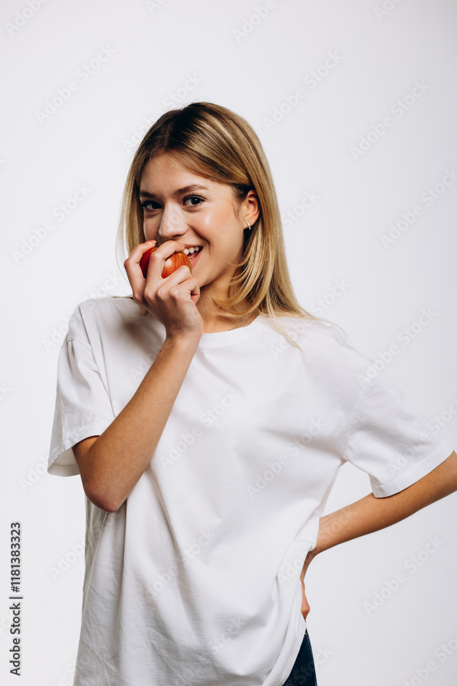 Young girl isolated on white background bites an apple Young girl isolated on white background bites an apple
