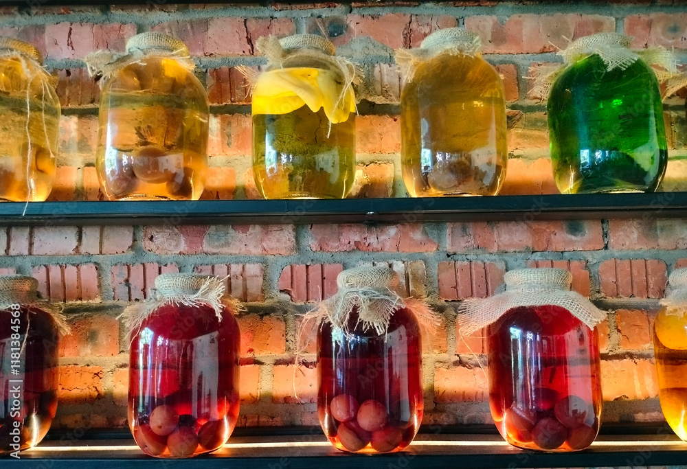 Canned vegetables and fruits in large glass jars on display. Homemade pickles and marinades.