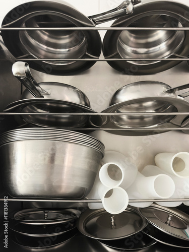 Still life urine bottles and stainless steel bedpans on racks
