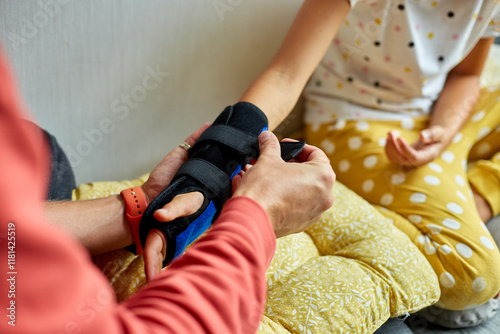 Physical Therapist Fitting a Support Brace on a Young Girls Arm