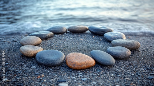Unique arrangement of smooth stones forming a circular pattern on dark sand