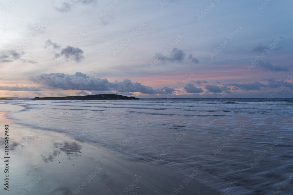 Lever de soleil à l'Aber avec un ciel pastel mêlant bleu et rose. Les nuages délicats se reflètent dans l'eau et le sable, créant une scène apaisante et poétique. Lever de soleil à l'Aber avec un ciel pastel mêlant bleu et rose. Les nuages délicats se reflètent dans l'eau et le sable, créant une scène apaisante et poétique.
