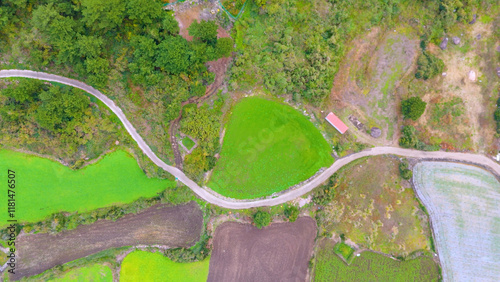 It's winter under Mt. Sanbang on Jeju Island, but it's a view of the village with green rice paddies and fields. Filmed with drones photo