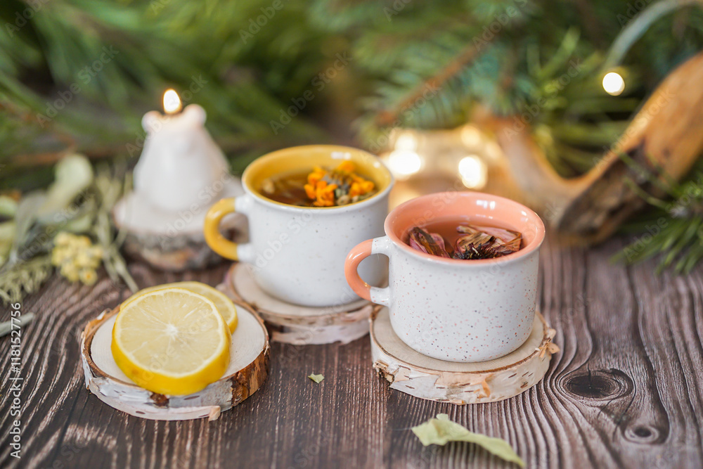 Fototapeta premium Cozy winter vibes with herbal tea, dried citrus slices, and seasonal decor – Christmas lights and fir tree branches