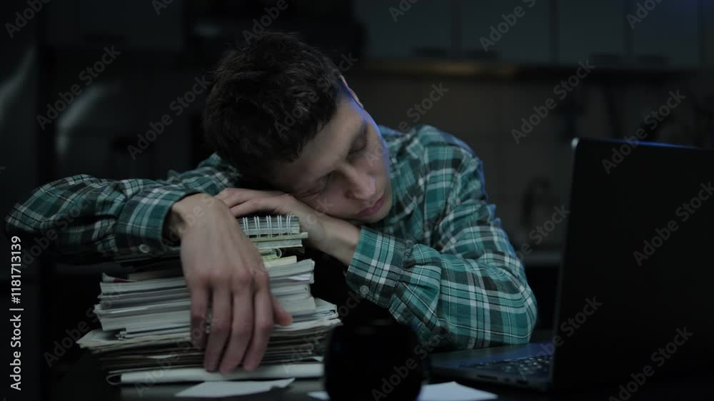 Boring tired young student or freelancer falling asleep during study or work at home workplace at late night. Man exhausted from remote distance work or education and hard program indoors
