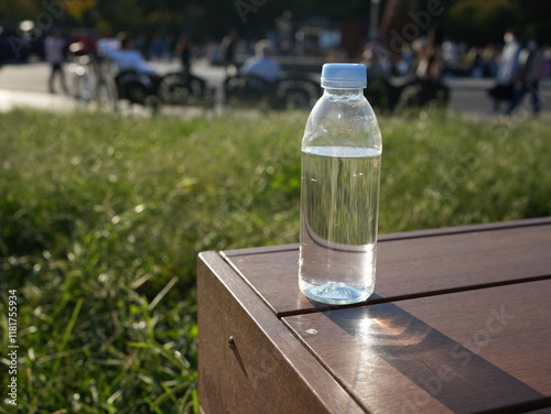 公園のベンチに置かれた水入りのペットボトル
