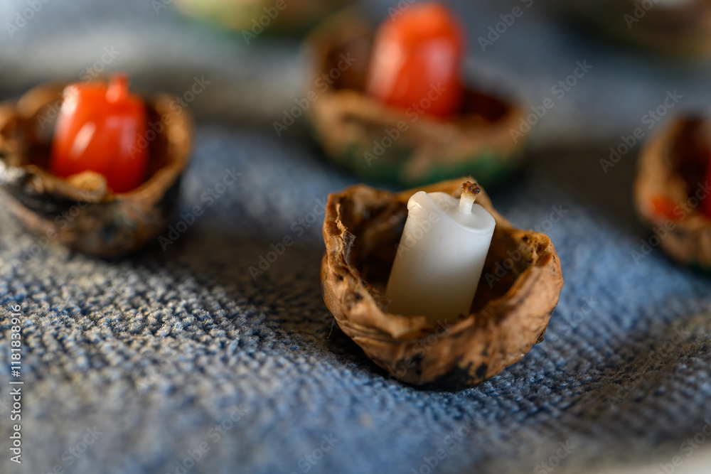 Nut shells with an unlit candle.
Nut shells with an unlit candle.