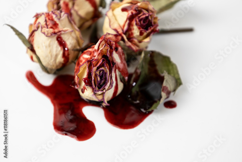 Fototapeta Naklejka Na Ścianę i Meble -  A Bloody dead buds of rose with blood on a white background. Dry flowers of the rose.