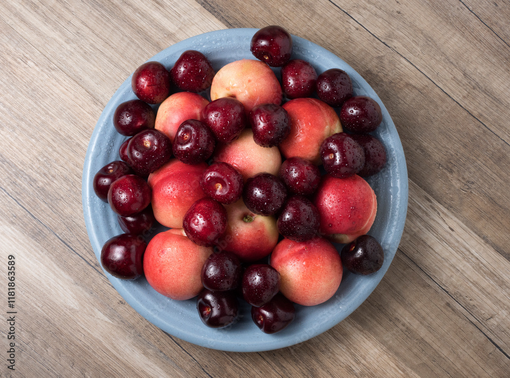 Sweet cherries and ripe juicy nectarines in a dish, on wooden background. Sweet cherries and ripe juicy nectarines in a dish, on wooden background.