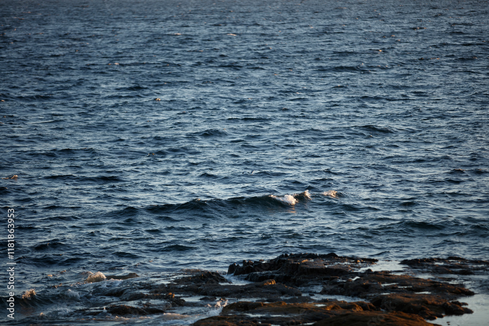 Fototapeta premium Calm waters of Isle of Skye at dusk reveal the beauty of Scotland's coastline and rocky shores
