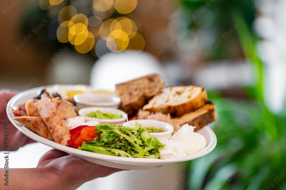 A beautifully arranged plate featuring sausages, poached eggs, fresh salad, and toasted bread, set against a blurred background with warm bokeh lights. Perfect for food-related themes. A beautifully arranged plate featuring sausages, poached eggs, fresh salad, and toasted bread, set against a blurred background with warm bokeh lights. Perfect for food-related themes.