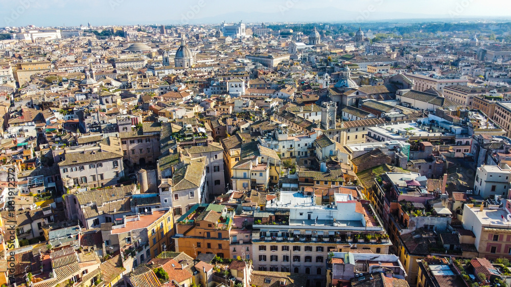 Foto aérea da arquitetura clássica da cidade de Roma, Itália, destacando seus monumentos históricos e ruínas antigas. A imagem captura a grandiosidade e a beleza cultural dessa cidade histórica