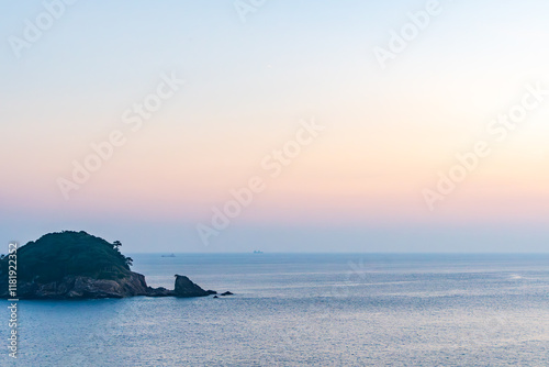 穏やかな夕暮れに染まる海と小島 photo