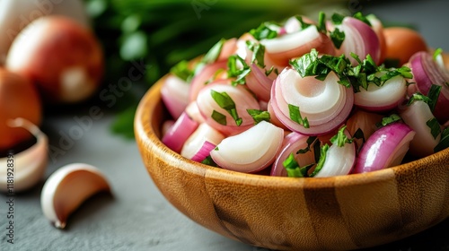 A vibrant mix of sliced red onions and fresh herbs elegantly arranged in a wooden bowl, perfect for showcasing freshness and culinary creativity in food photography. photo