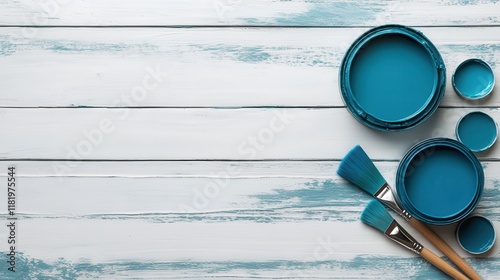 An artistic setup featuring various blue paint cans and brushes on a rustic wooden table, symbolizing creativity and artistic expression in a serene environment. photo