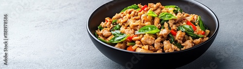 Delicious stir-fried chicken with vegetables served in a black bowl.