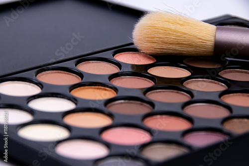 Professional makeup palette with a variety of shades and a brush ready for application on a clean surface in a well-lit area