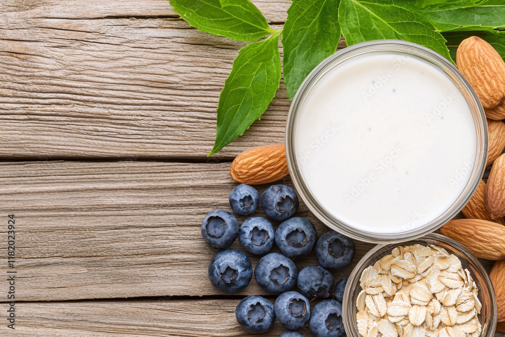 light and healthy smoothie made from blueberries, oats, and almonds, surrounded by fresh leaves on rustic wooden background. Perfect for nutritious snack! light and healthy smoothie made from blueberries, oats, and almonds, surrounded by fresh leaves on rustic wooden background. Perfect for nutritious snack!