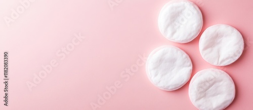 Woman's face with healthy clean skin using cotton pads on soft pink background for beauty and skincare routine removal of makeup photo