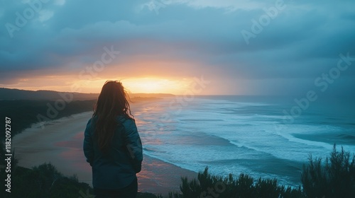 Young woman with long hair gazes at vibrant coastal sunrise over blue ocean waves near Coffs Harbour Australia, capturing serene natural beauty and tranquility. photo