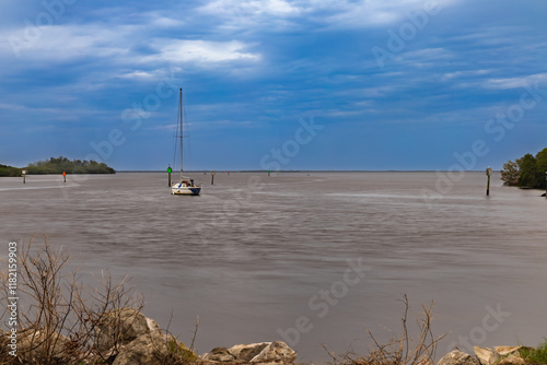 The landscape photo of a boat at the Anclote River Park the ripples of the water provide a timeless feel photo