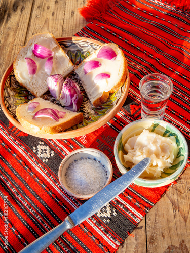 pork lard spread on bread served with red onion and salt and glass of plum brandy aside photo