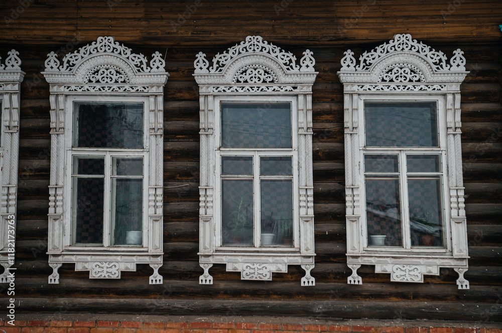 carved window frames in log houses in a Russian village