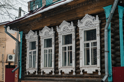 carved window frames in log houses in a Russian village photo