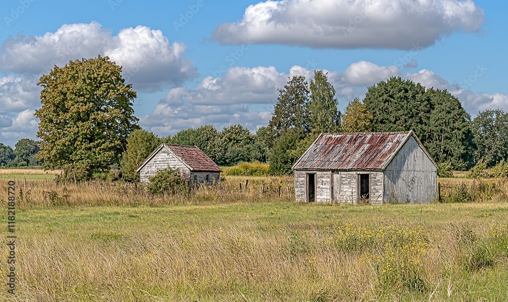 Old wooden barns in a field under a cloudy sky. Old wooden barns in a field under a cloudy sky.
