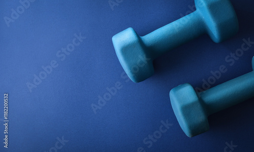 Two octagonal blue neoprene dumbbells isolated on blue background
