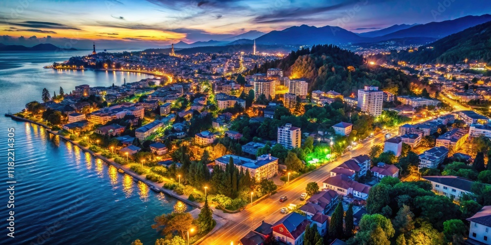 Fototapeta premium Aerial view: Sukhumi's resort town glows, a vibrant tapestry of city lights at night.