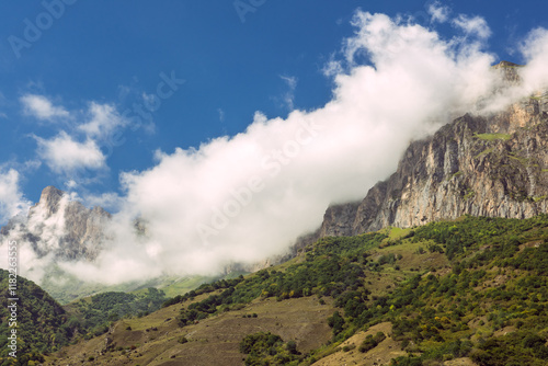 Caucasus, green mountains. View on the enchanting hills and blue sky with white cottony clouds