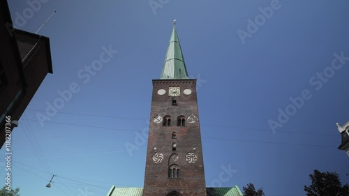 City Centre on a busy day with many pedestrians on a Sunny Day in Summer , Architecture of the city, Aarhus Cathedral, Church, View of shopping street city centre  photo
