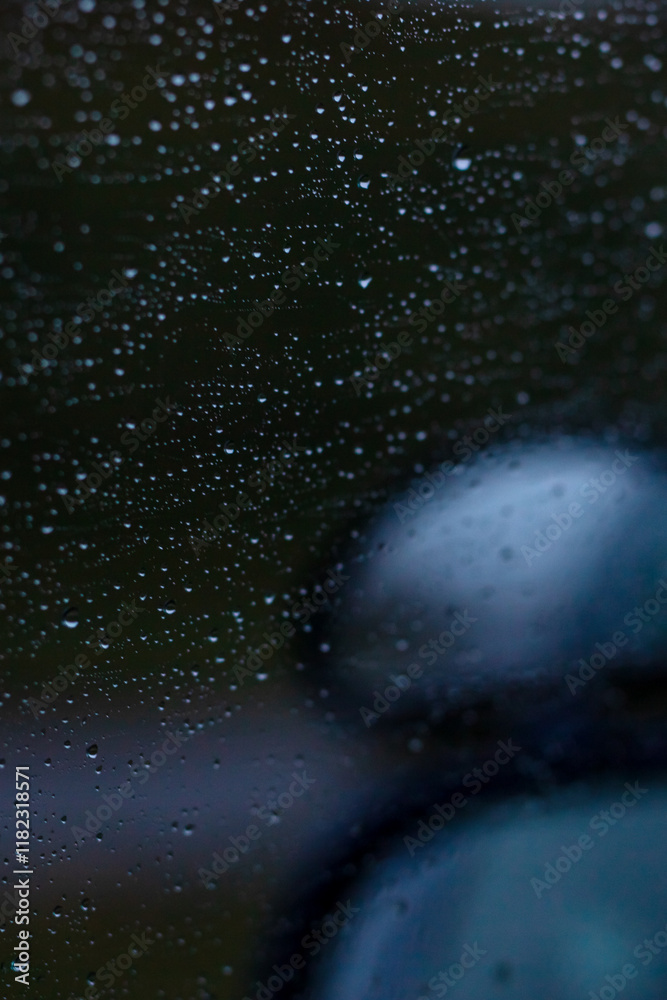 Fototapeta premium Closeup of a cars rearview mirror with raindrops on it