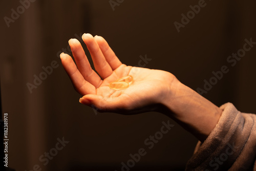 Hand holding omega 3 supplements displayed in warm lighting for health and wellness focus