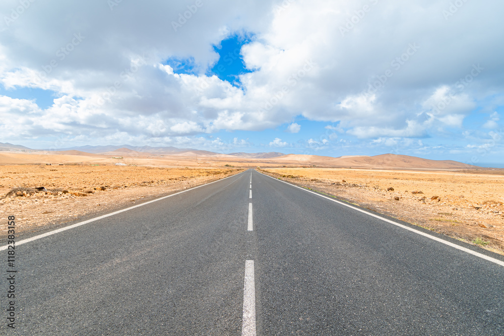 Grande ligne droite sur une route au milieu du désert à Fuerteventura, île des Canaries, Espagne. Grande ligne droite sur une route au milieu du désert à Fuerteventura, île des Canaries, Espagne.