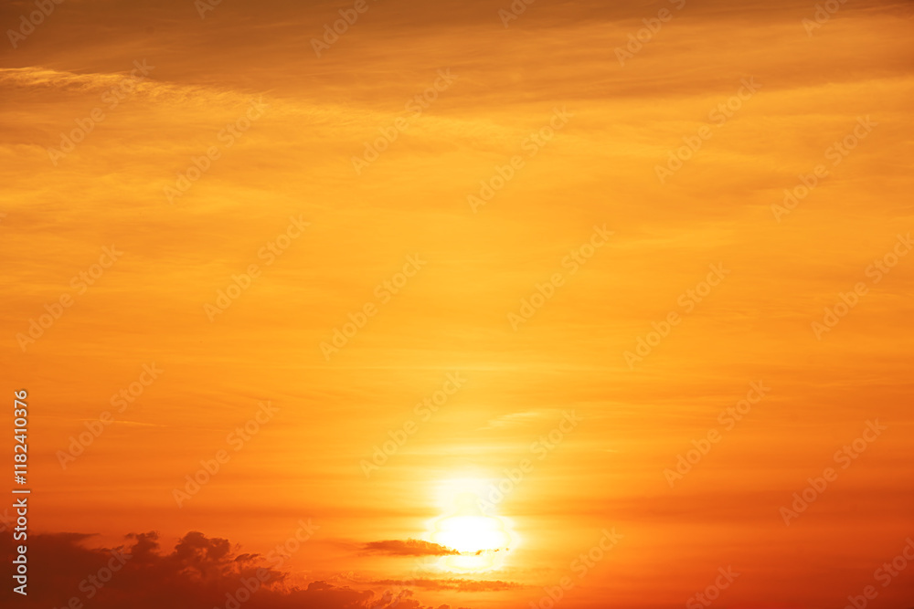 Golden sunset sky with glowing light and clouds.