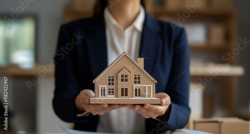 Real estate woman presentation a 3D house model during a real estate investment meeting in a professional office setting.
